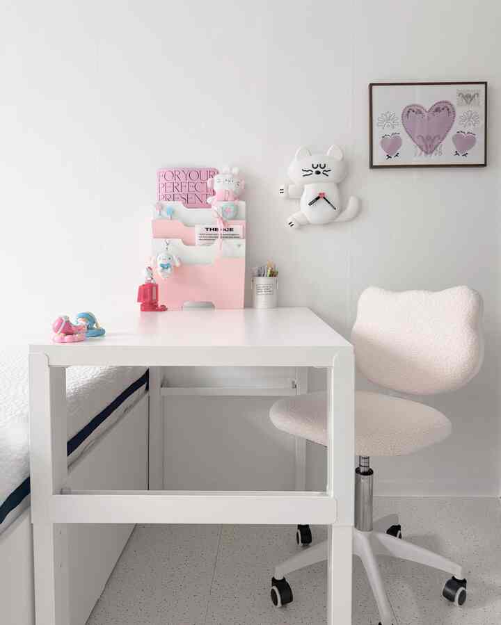 白を基調とした子供部屋、かわいいキャラクターの小物とシンプルな机が配置された落ち着いた空間