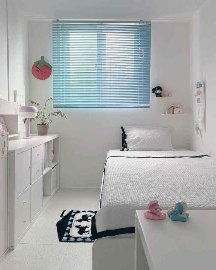 白とスカイブルーのトーンの子供部屋、ベッドと本棚が配置されたシンプルで清潔感あるインテリア