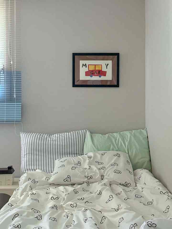 柔らかなホワイトとナチュラルカラーの子供部屋、子供用ベッドと車のポスターが配置された雰囲気のあるインテリア