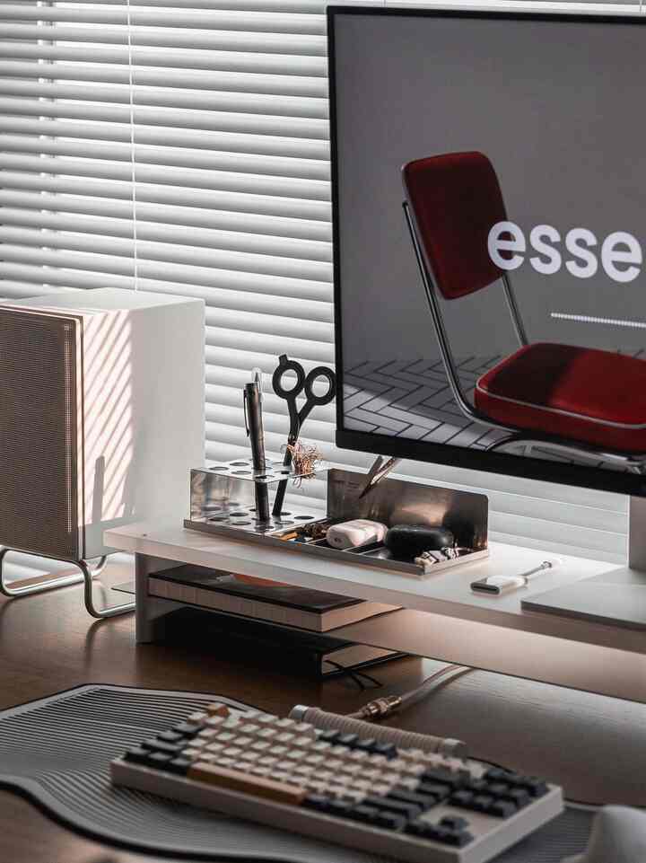 白と茶色の木目調を基調としたコンパクトでシンプルなホームオフィスのデスクセットアップ、モニタースタンドとスピーカーが配置されたインテリア