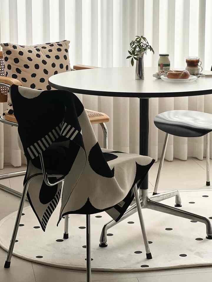 White and black toned dining room featuring a round dining table and modern chairs in a clean cafe style setting
