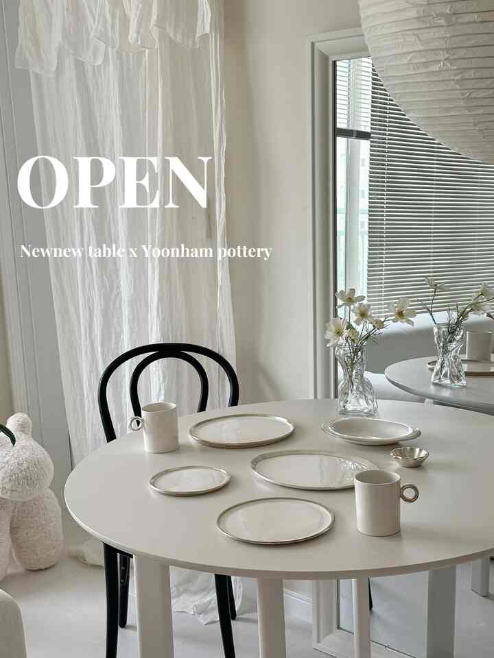 白とシルバー調のリビングダイニングテーブル、シンプルなマグカップと皿が配置された雰囲気ある空間