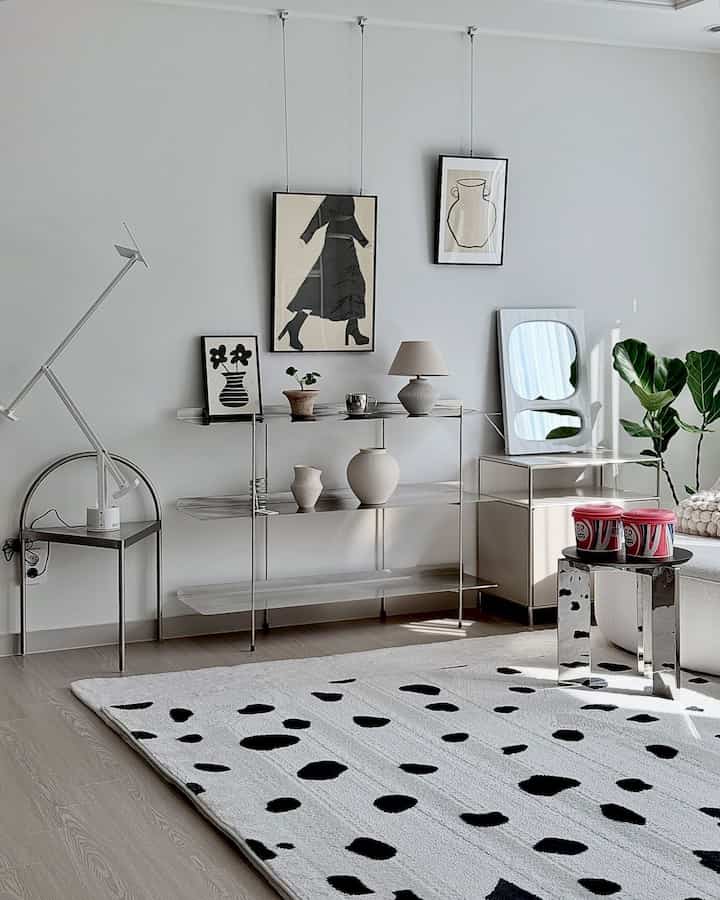 White and beige toned living room featuring steel shelves and a Dalmatian patterned rug in a modern, clean space