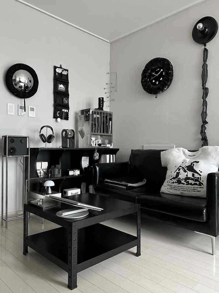 Modern black and white toned living room featuring a black leather sofa and metal coffee table, clean and stylish space