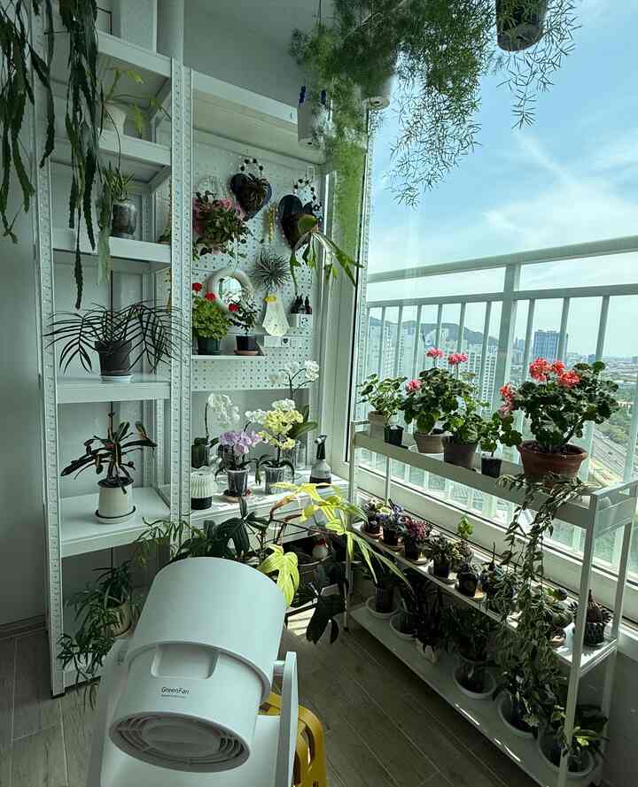 ホワイトトーンのバルコニー空間、多様な植物と棚が配置された自然の雰囲気のあるインテリア