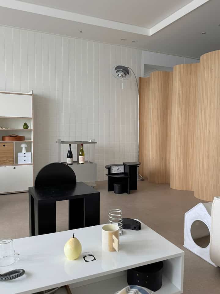 Modern single household living room with white and wood tones, featuring pet house and organized storage ideas