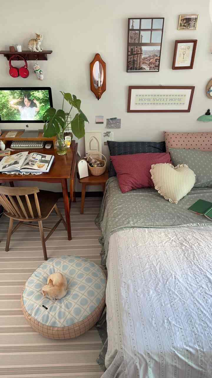 ナチュラルな木目調と柔らかな寝具が調和する、デスクとペットクッションが配置された居心地の良い寝室