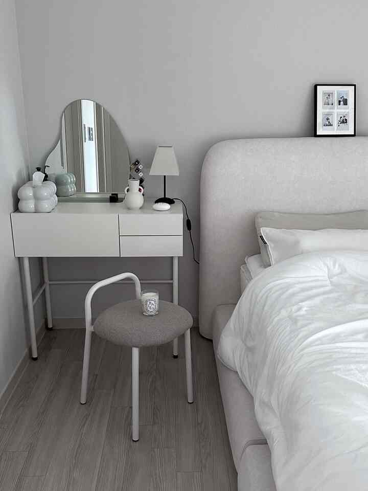 ホワイトとグレーのトーンの寝室、快適なベッドとミニマルな化粧台が配置されたシンプルな空間