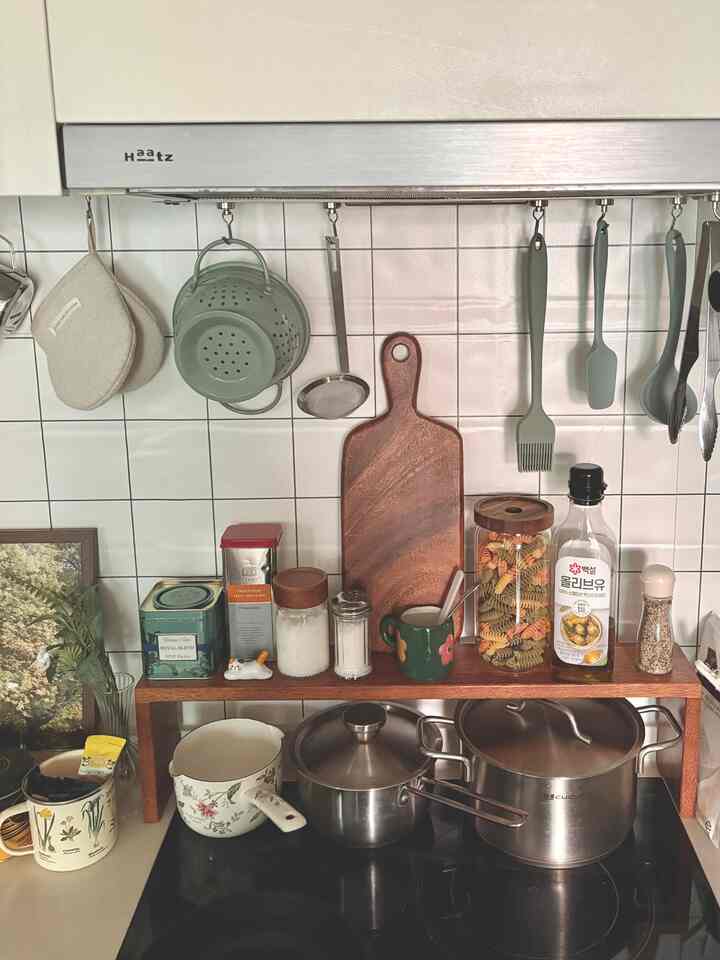 ナチュラルカラーと木目調が調和したキッチン、調理器具と収納アイテムが整頓された雰囲気のあるインテリア