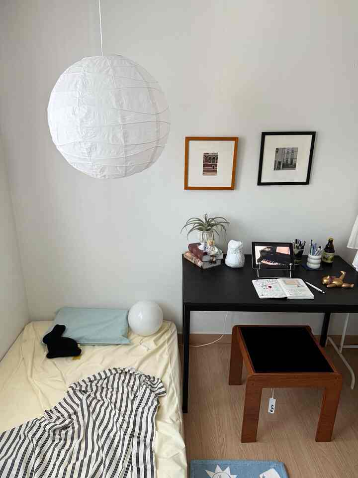 ホワイトとナチュラルな色調の狭い寝室、デスクとオグレサイドテーブルが配置された雰囲気のあるインテリア