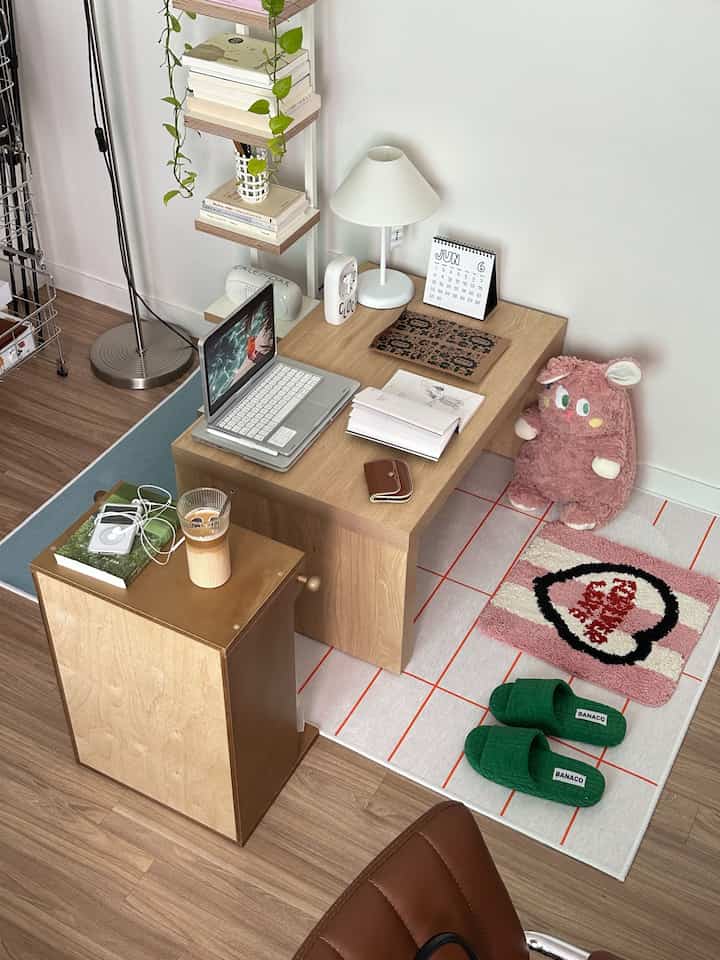 ナチュラルモダンの色調の小さなワークスペース、木製の机とランプ、ノートパソコン、ラグが配置された雰囲気のあるインテリア