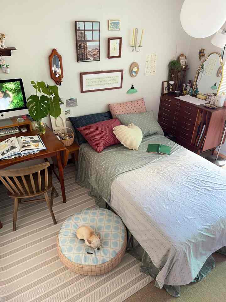 White-walled natural wood two-person bedroom featuring a desk and pet bed with cozy atmosphere