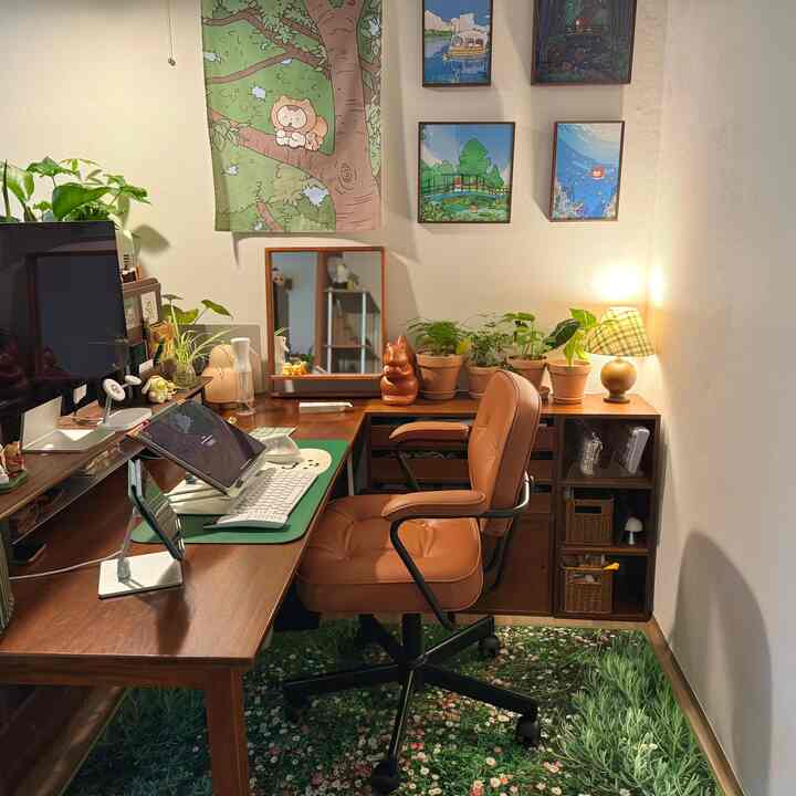 温かみのある木目調と緑の植物が調和したコンパクトなホームオフィス、モダンなオフィスチェアと花柄ラグが配置された居心地の良い空間