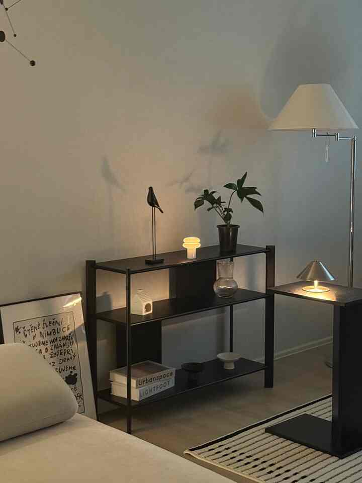 ベージュのソファと黒い棚、フロアランプが配されたモダンで落ち着いたリビング