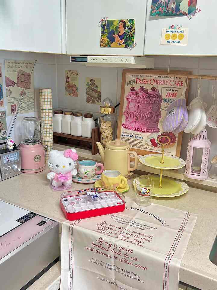 ピンク色とヴィンテージ風のキッチン、ハローキティのぬいぐるみとキッチン用品がかわいらしく配置された雰囲気のあるインテリア