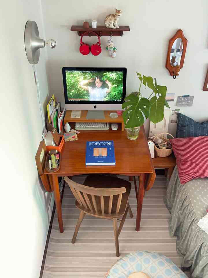木目調の机と椅子、緑の植物が置かれた落ち着いた1人用のワークスペース