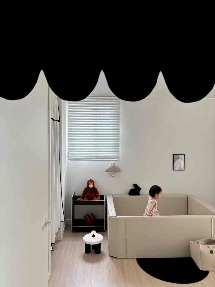 ベージュとホワイトのトーンの子供部屋、ベージュのソファと遊び用家具が配置されたシンプルで明るい雰囲気のある空間