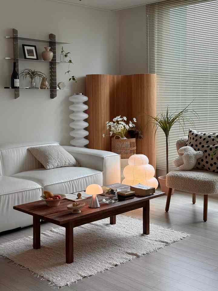 白と木目調の調和がとれたリビング、ソファとコーヒーテーブルが配置された温かみのある自然な雰囲気のインテリア