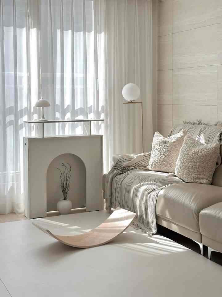 明るいベージュとホワイトのトーンのリビングルーム、レザーソファとシアーカーテンが配置された自然なモダンな雰囲気の空間