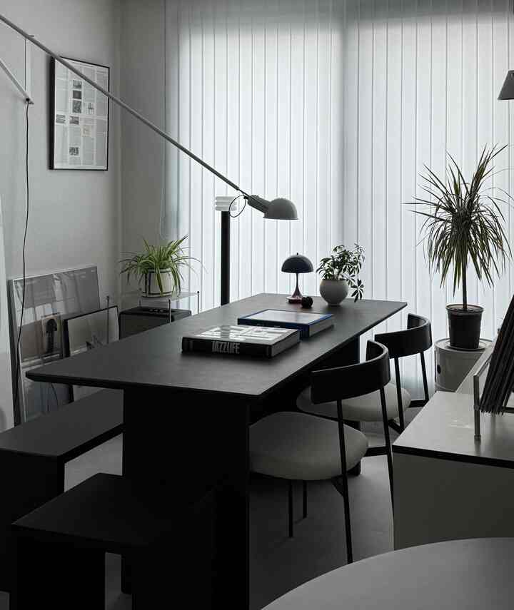 ホワイトブラインドと黒のダイニングテーブル、ミニマルな雰囲気のリビングルーム