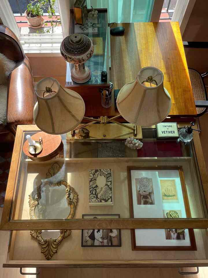 ウッドトーンとアイボリーの色調のリビング、ヴィンテージ感のある大型コーヒーテーブルとクリーム色のテーブルランプが配置された空間