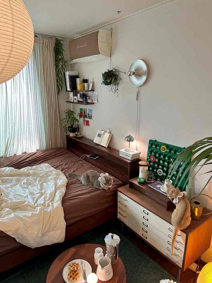Brown and white toned bedroom featuring wooden bed frame and plants in a cozy atmosphere