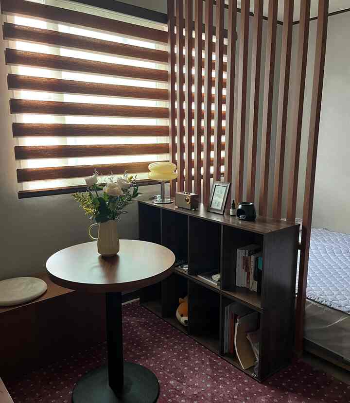 木目調のベランダ空間、花瓶と本棚が配置された居心地の良いおうちカフェの雰囲気ある小さな部屋