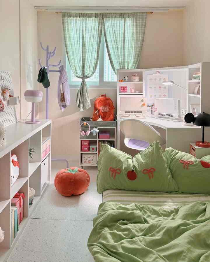 淡いグリーンとホワイトの色調のコンパクトな部屋、コーナーデスクと棚、ベッドが配置された印象的な空間