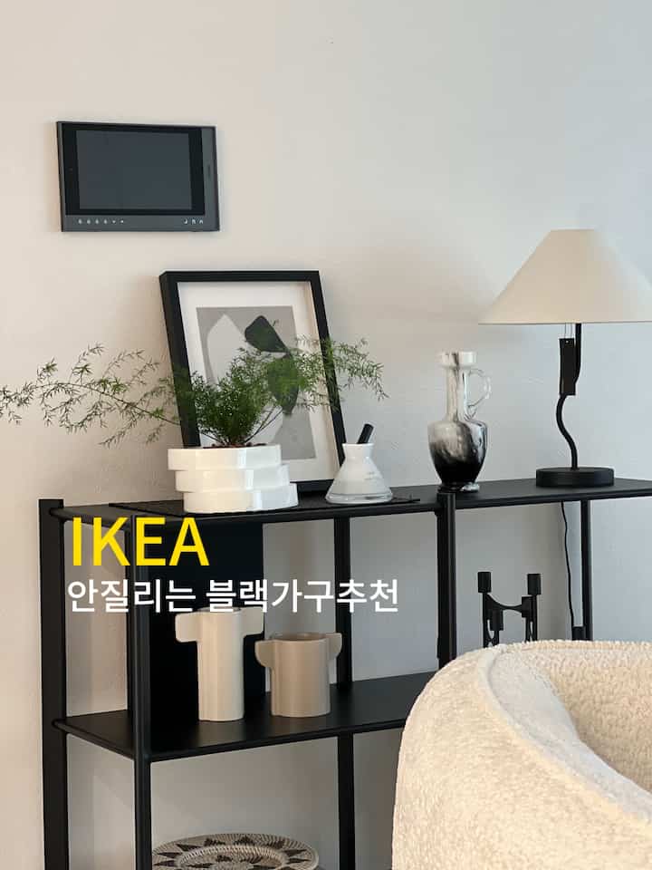 黒い棚と白い壁、ベージュの椅子が調和するモダンなリビング空間