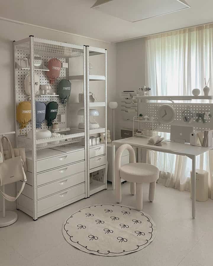 ホワイトとナチュラルカラーの子供部屋、引き出し付きの鉄製棚とデスク、かわいらしい小物が配置された清潔感のある空間