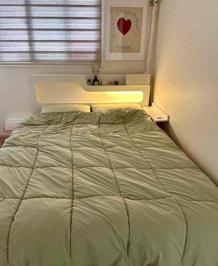 ナチュラルカラーの6畳寝室、中央に大きなベッドと柔らかな間接照明が配置された落ち着いた雰囲気のあるインテリア