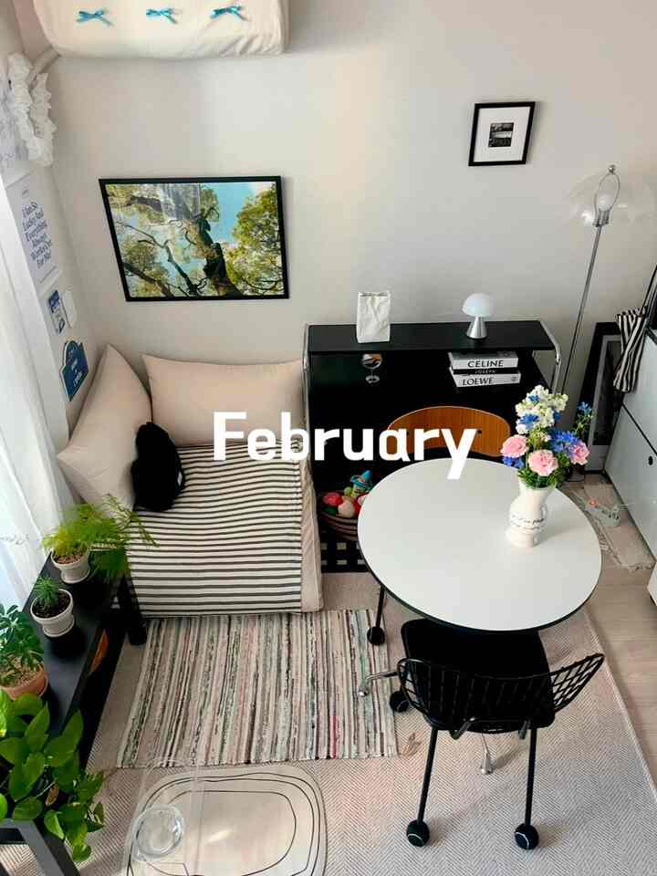 白と黒の調和がとれたコンパクトなリビング、丸テーブルとファブリックソファが配置されたシンプルでナチュラルなインテリア