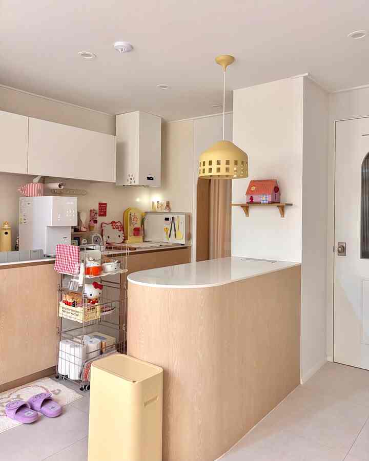 White and natural wood tone kitchen featuring a kitchen island and storage trolley, clean and organized interior