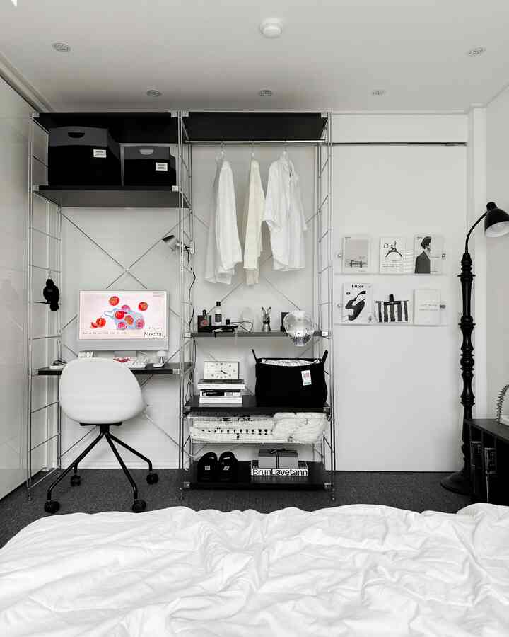 Monotone small room featuring white and black walk-in closet and desk with modern workspace setup