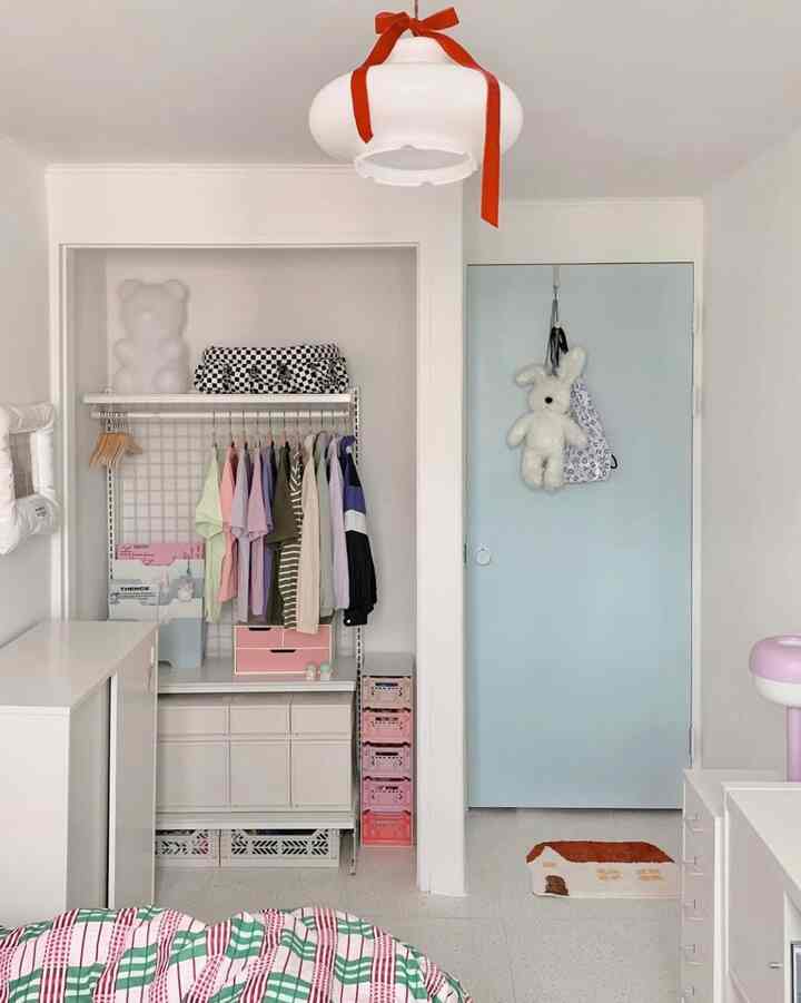 Pastel-toned small kids' room featuring a sky blue door and organized storage creating a cozy atmosphere
