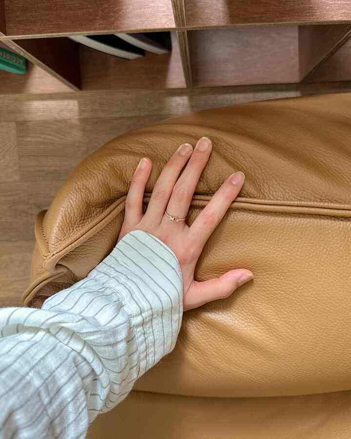 ブラウンの木目調が特徴のワンルーム、ナチュラルなレザーのビーズクッションが配置された印象的な空間