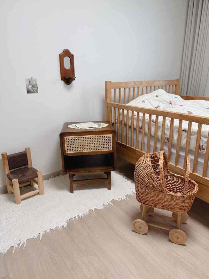 Natural tone kids' room featuring wooden furniture and rug with cozy warm atmosphere