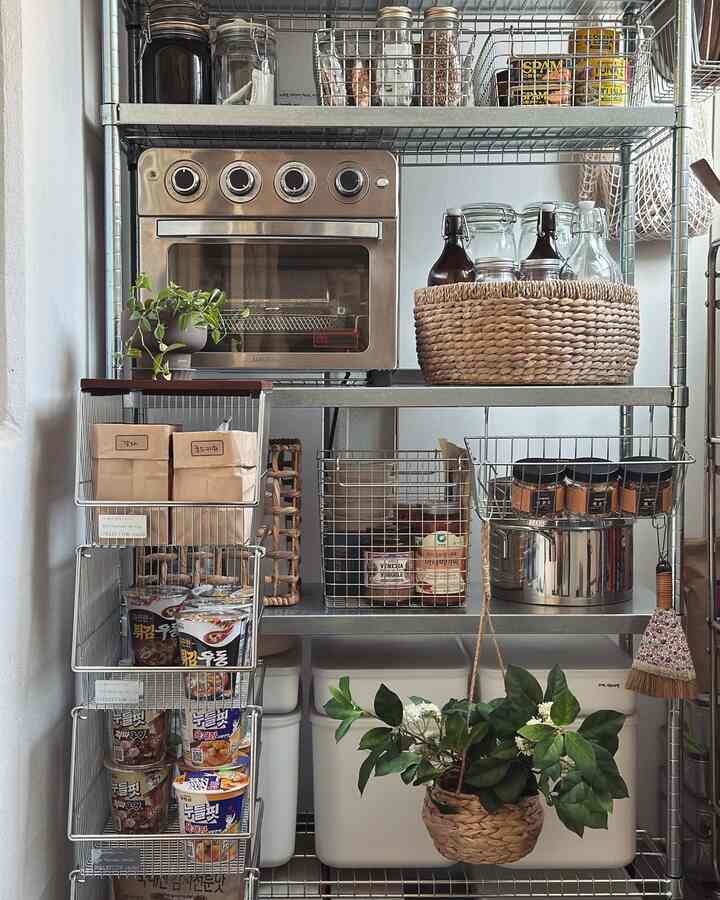ナチュラルカラーのキッチン収納スペース、金属製の棚とガラス瓶、整理された食品容器が配置された清潔感のあるインテリア