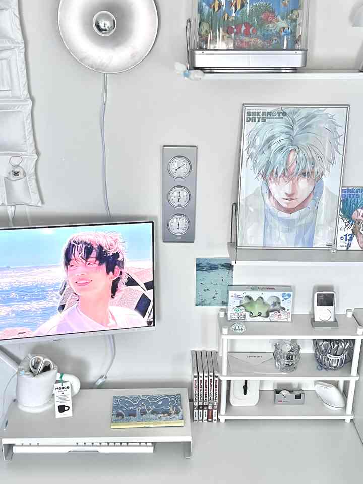 白とシルバーの調和が美しいモダンなホームオフィス空間、額縁や時計が配置された整然としたデスク環境