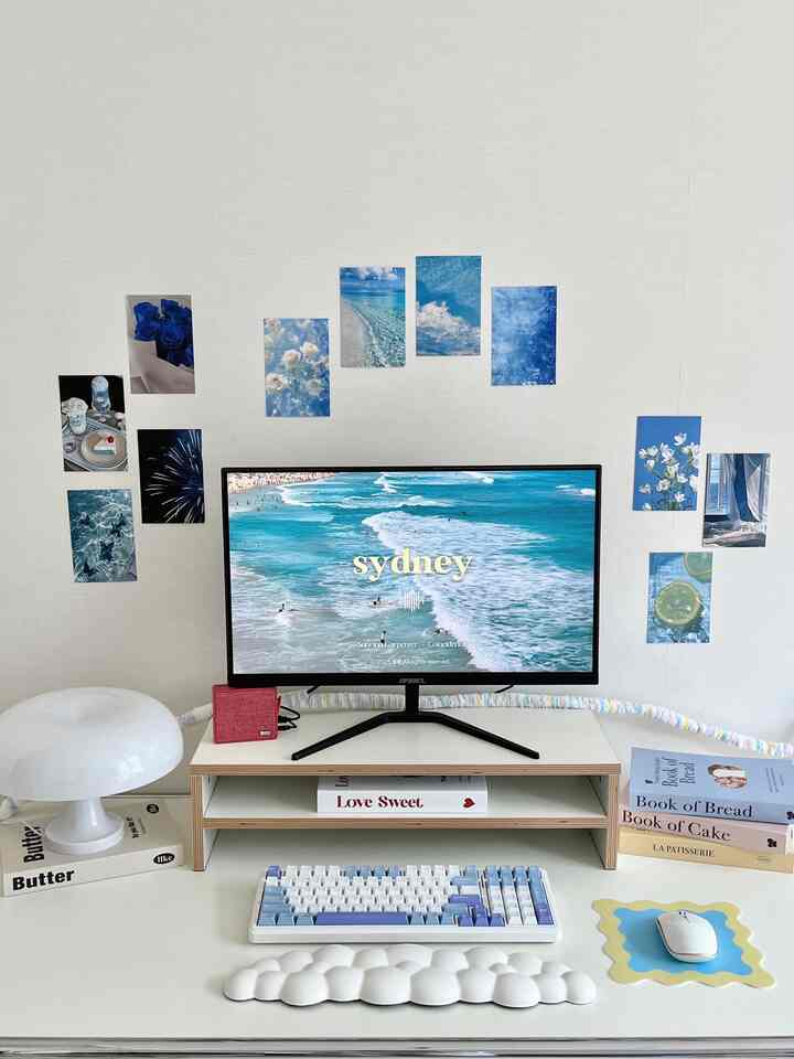 White and blue toned home office featuring Mid-Century Modern desk, monitor stand and keyboard in a neat workspace