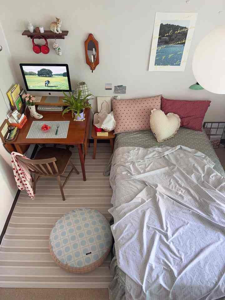 ナチュラルな木目調とベージュ・グレーの色調が調和した一人暮らしの小さなホームオフィス兼寝室空間