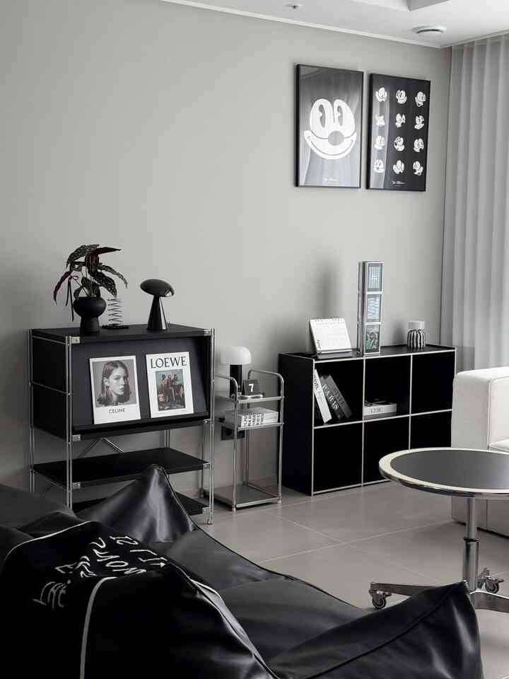 モノトーンの黒とシルバーのトーンが特徴的なリビング、ビーズクッションソファとモダンな家具が配置された洗練されたインテリア