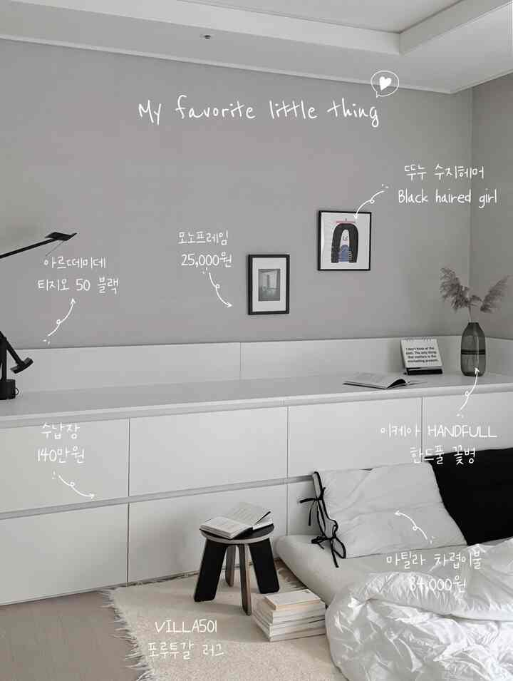 ホワイトとナチュラルカラーのリビング、キャビネットやラグ、モダンな額縁とテーブルランプが配置された印象的なインテリア