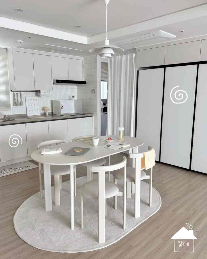 白と木目調のキッチン、白いダイニングテーブルと椅子が配置されたモダンでナチュラルな雰囲気のインテリア
