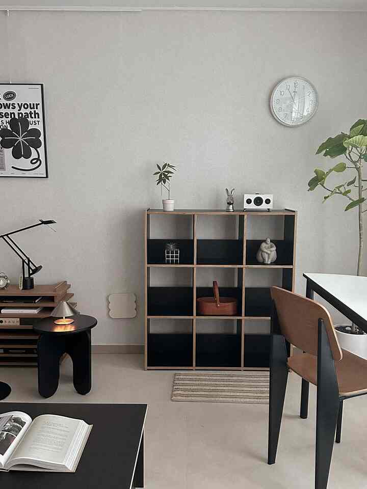 ナチュラルモダンの色調のダイニング、木製の本棚とダイニングチェアが配置されたシンプルで整った空間