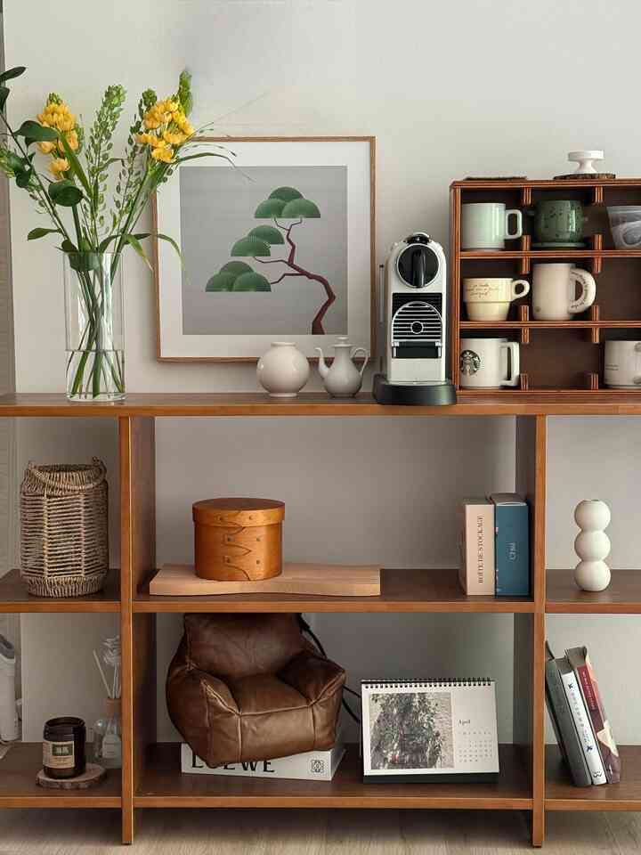 白い壁と茶色い木製の棚がある北欧風のおうちカフェ、コーヒーマシンと整然としたオブジェが配置された雰囲気のあるインテリア