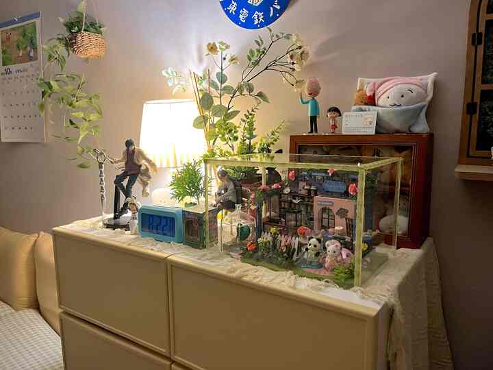 白とナチュラルカラーの寝室空間、テーブルランプとさまざまなインテリア小物が配された落ち着いた雰囲気のインテリア