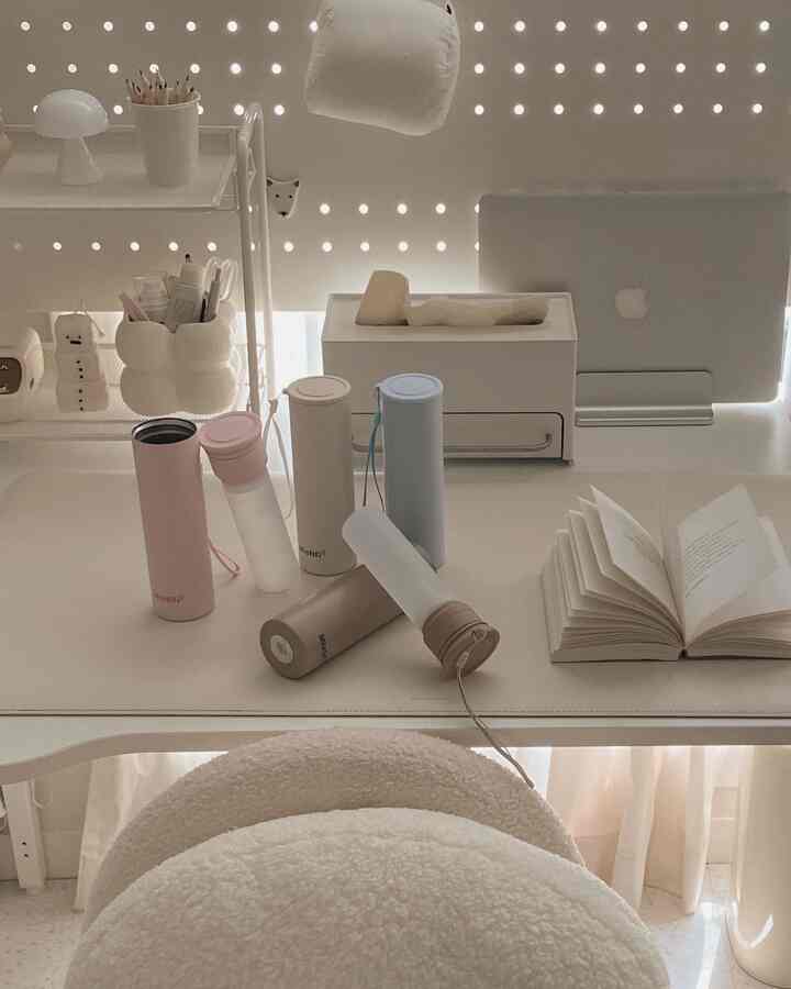 ホワイトとベージュのトーンが基調の子供部屋のデスク、多様なタンブラーや収納用品が整然と配置されたモダンな空間