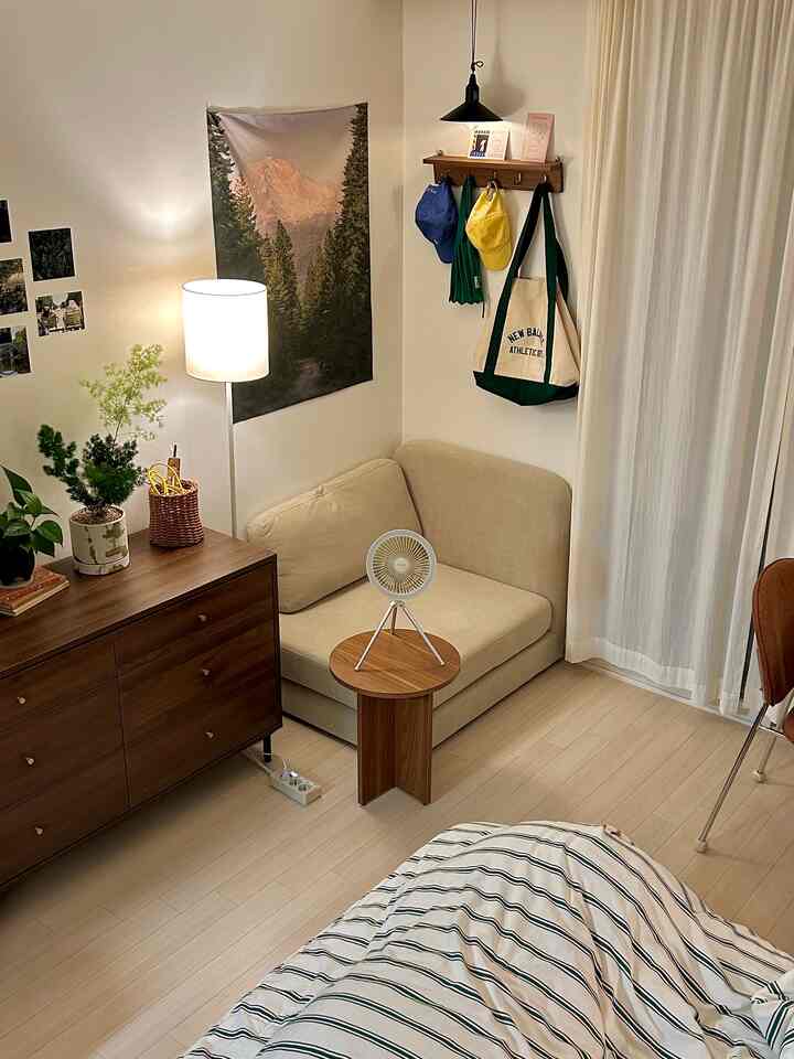 ベージュのソファと木製家具が配置された7坪のワンルーム、植物と暖かい照明が調和するナチュラルでヴィンテージ感のある空間