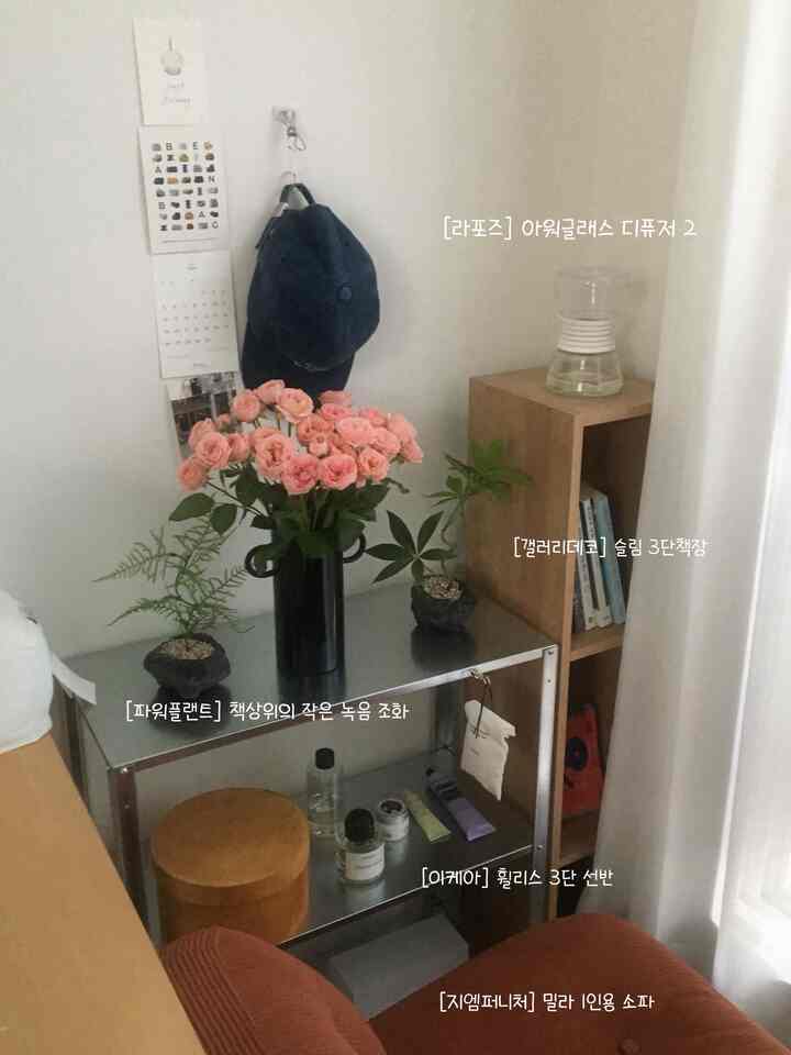 ナチュラルな色調の3坪の小さな部屋、シルバーの金属棚と木製の3段本棚、1人用ソファとデスクが配置された作業と休憩の空間